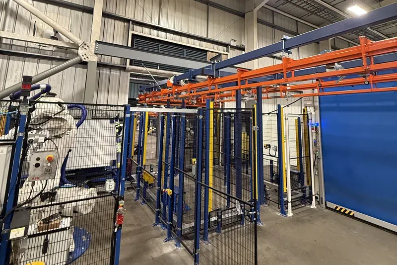 Amber Industries overhead conveyor installation positioned above automated automotive manufacturing equipment